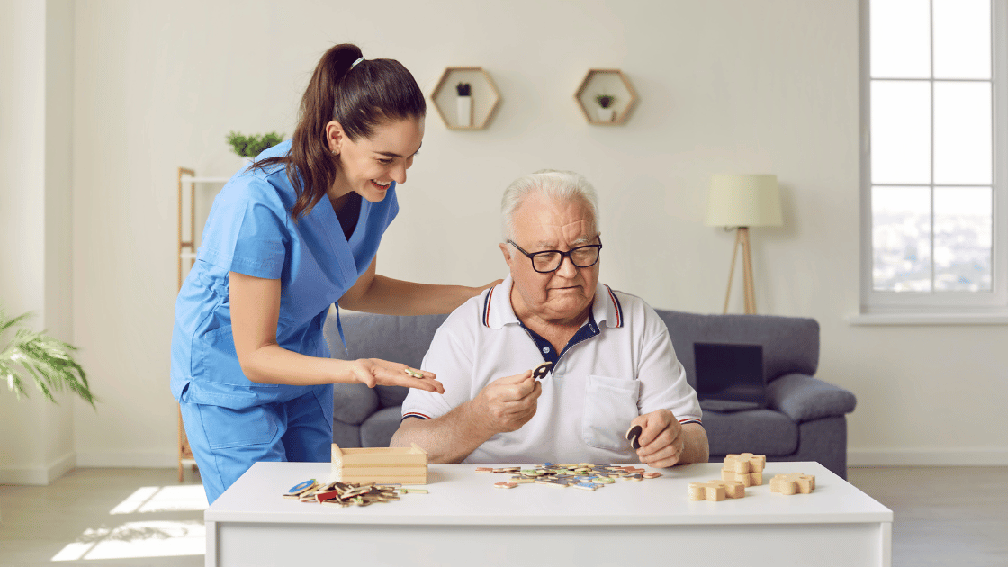 A nurse assisting an elderly man with a puzzle, providing care and support in a compassionate manner.